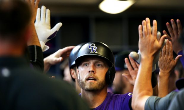 Mark Reynolds #12 of the Colorado Rockies is congratulated by teammates after hitting a home run in...