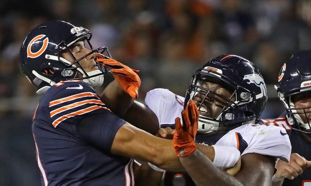 CHICAGO, IL - AUGUST 10: Mitchell Trubisky #10 of the Chicago Bears is hit by Shelby Harris #96 of ...