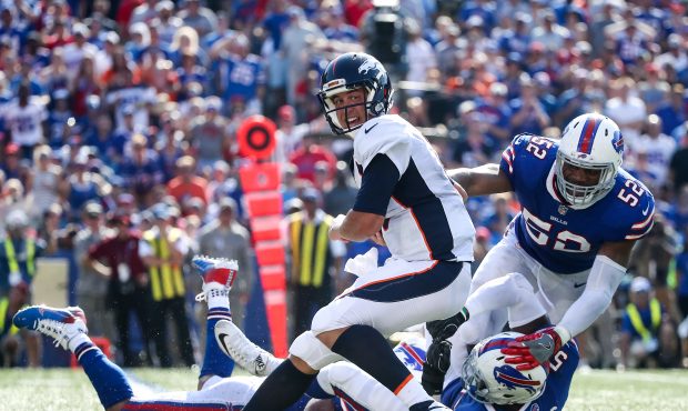 ORCHARD PARK, NY - SEPTEMBER 24: Trevor Siemian #13 of the Denver Broncos is tackled by Lorenzo Ale...