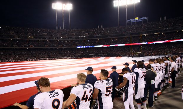 OAKLAND, CA - NOVEMBER 06:   Denver Broncos players salute a giant American flag during the nationa...