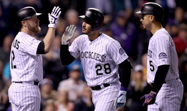 DENVER, CO - SEPTEMBER 26:  Nolan Arenado #28 of the Colorado Rockies is congratulated by Mark Reyn...