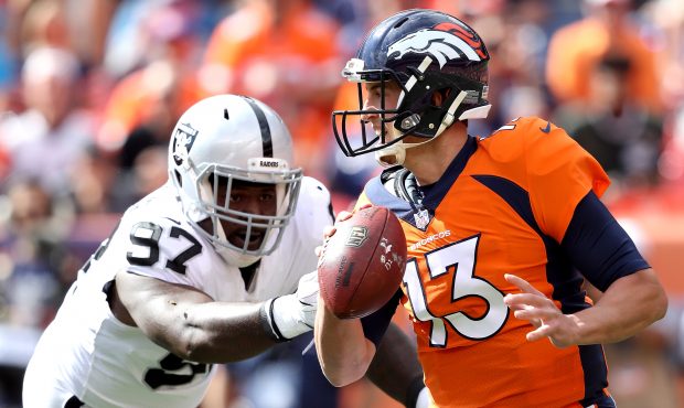 DENVER, CO - OCTOBER 01:  Trevor Siemian #13 of the Denver Broncos tries to escape from Mario Edwar...
