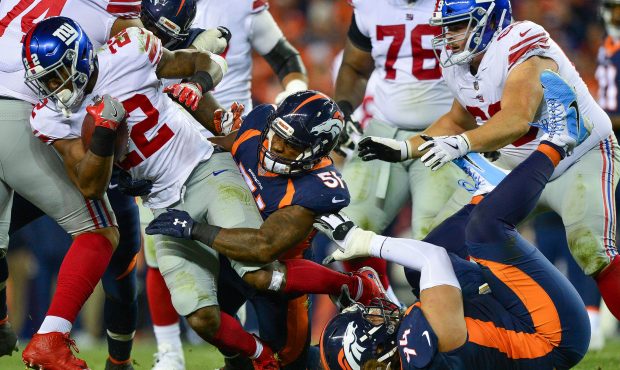 Running back Wayne Gallman #22 of the New York Giants is hit by inside linebacker Todd Davis #51 of...
