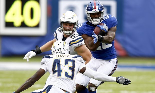 EAST RUTHERFORD, NJ - OCTOBER 08:  Wayne Gallman #22 of the New York Giants runs into Michael Davis...