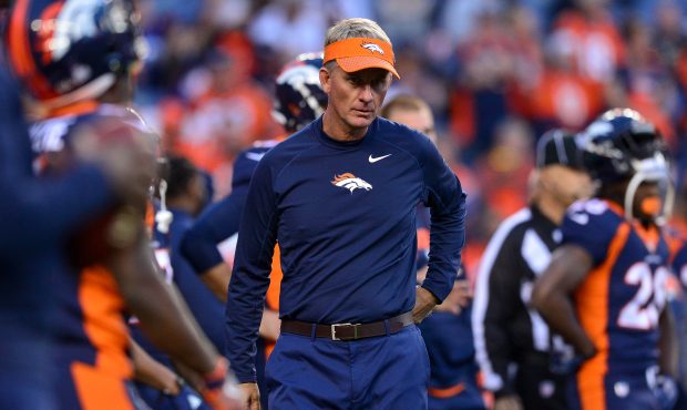 Offensive coordinator Mike McCoy stands not he field as players warm up before a game between the D...