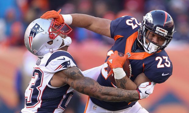 DENVER, CO - DECEMBER 18:  running back Devontae Booker #23 of the Denver Broncos gives a stiff arm...