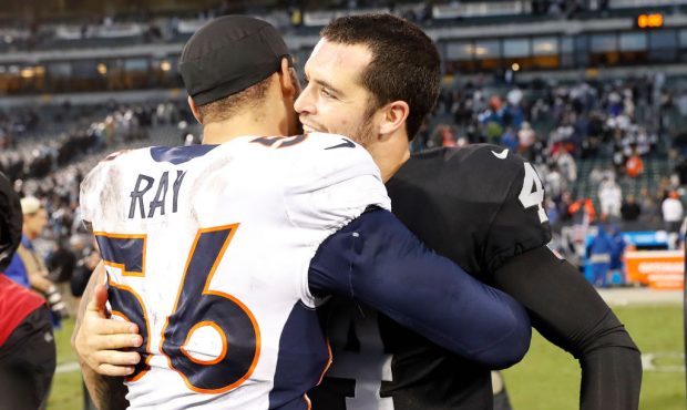 OAKLAND, CA - NOVEMBER 26: Quarterback Derek Carr #4 of the Oakland Raiders embraces Shane Ray #56 ...