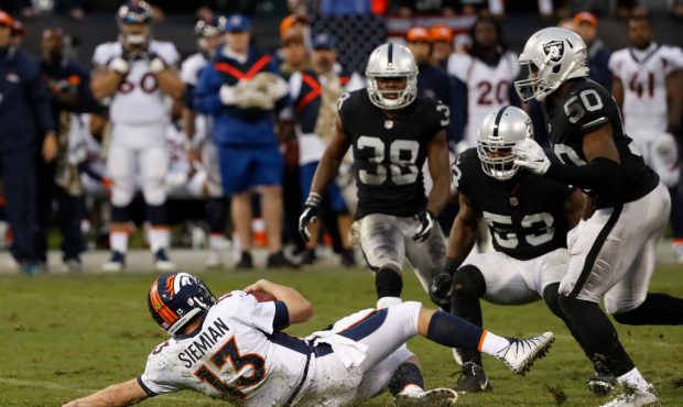 OAKLAND, CA - NOVEMBER 26: Quarterback Trevor Siemian #13 of the Denver Broncos slides after rushin...