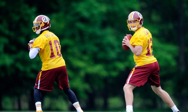 Robert Griffin III #10 and Kirk Cousins #12 of the Washington Redskins drop back to throw a pass du...