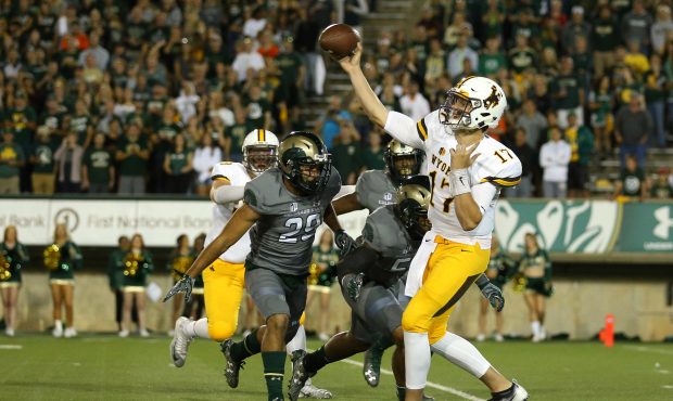 Quarterback Josh Allen #17 of the Wyoming Cowboys throws a pass under pressure from the Colorado St...