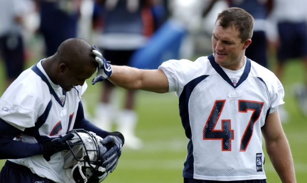 Denver Broncos John Lynch, right, wipes off grass from fellow Bronco, Champ Bailey's head during th...