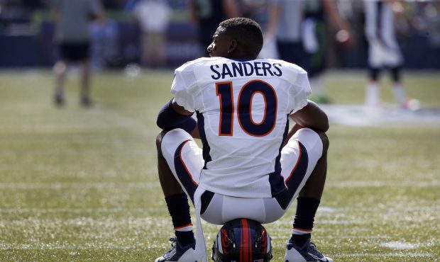 Wide receiver Emmanuel Sanders #10 of the Denver Broncos sits on his helmet before the game against...