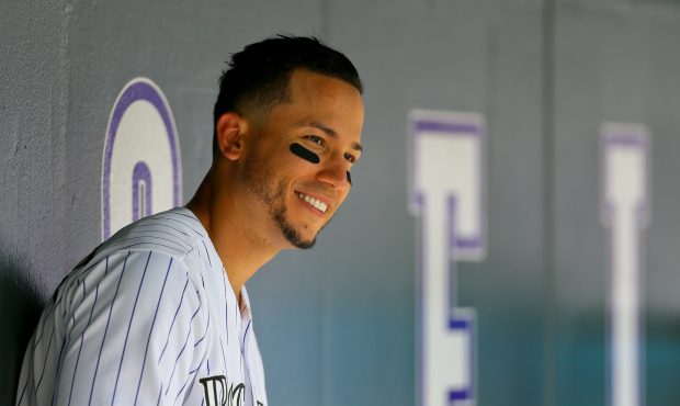 Carlos Gonzalez #5 of the Colorado Rockies smiles in the dugout during a game against the Cincinnat...