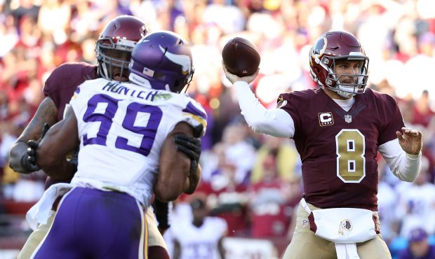 Quarterback Kirk Cousins #8 of the Washington Redskins passes the ball against defensive end Daniel...