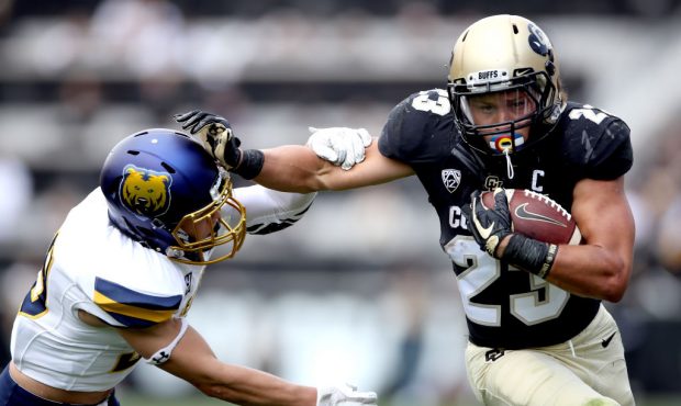 Phillip Lindsay #23 of the Colorado Buffaloes stiff arms Keifer Glau #39 the Northern Colorado Bear...