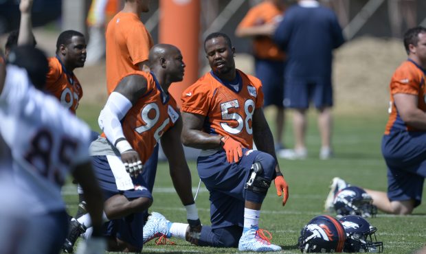 Denver Broncos DeMarcus Ware (94) talks with Von Miller (58) as they stretch during OTA's June 11, ...