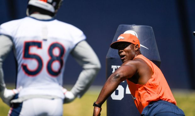 Former Denver Broncos linebacker DeMarcus Ware demonstrates technique as Von Miller (58) looks on d...