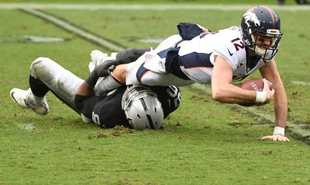 OAKLAND, CA - NOVEMBER 26:  Paxton Lynch #12 of the Denver Broncos is sacked by Denico Autry #96 of...