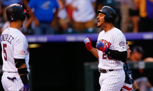 Nolan Arenado (28) of the Colorado Rockies celebrates his three-run home run before being congratul...