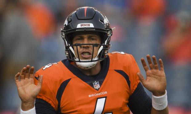 Case Keenum #4 talks with a teammate as the Denver Broncos warm up before taking on the Chicago Bea...
