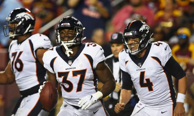 Running back Royce Freeman #37 and quarterback Case Keenum #4 of the Denver Broncos head to the sid...