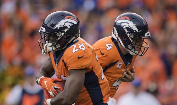 Denver Broncos quarterback Case Keenum (4) hand off to Denver Broncos running back Royce Freeman (2...