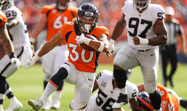 Running back Phillip Lindsay #30 of the Denver Broncos rushes against the Oakland Raiders at Bronco...