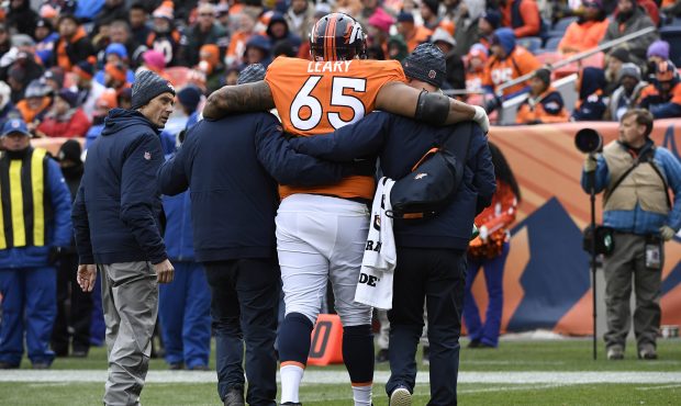 Ronald Leary (65) of the Denver Broncos is helped off the field during the third quarter against th...