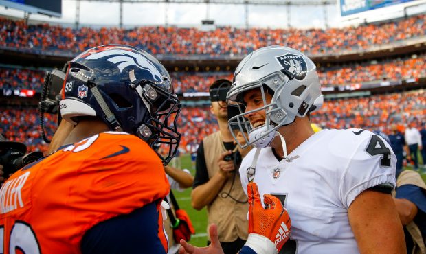 Linebacker Von Miller #58 of the Denver Broncos greets quarterback Derek Carr #4 of the Oakland Rai...