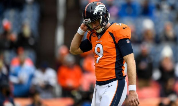 Quarterback Kevin Hogan #9 of the Denver Broncos walks on the field as players warm up before a gam...