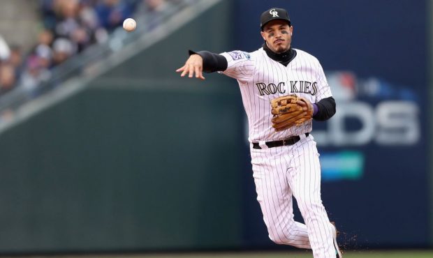 DENVER, CO - OCTOBER 07:  Nolan Arenado #28 of the Colorado Rockies throws out Travis Shaw #21 of t...