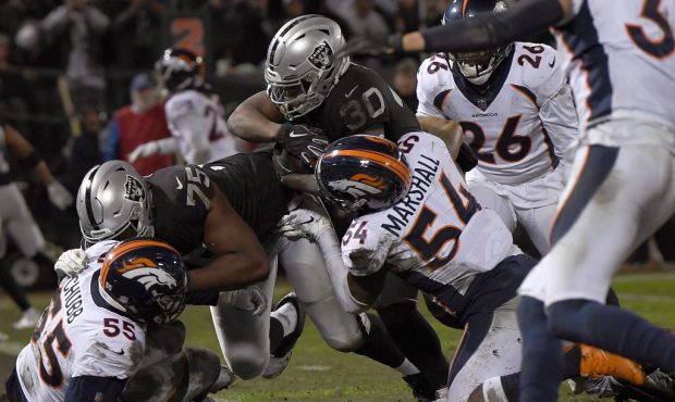 OAKLAND, CA - DECEMBER 24:  Jalen Richard #30 of the Oakland Raiders rushes for a touchdown draggin...
