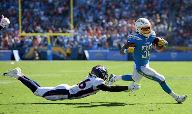 Austin Ekeler #30 of the Los Angeles Chargers turns the corner past Isaac Yiadom #26 of the Denver ...