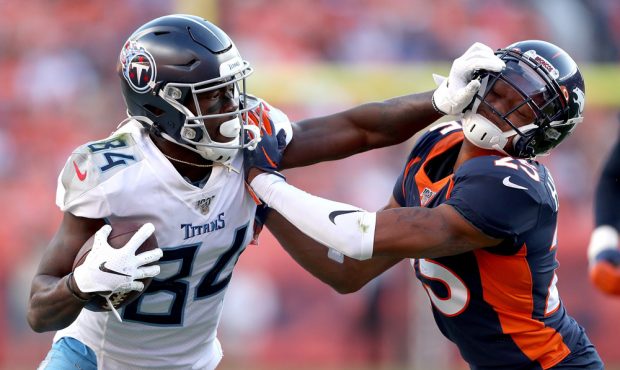 DENVER, COLORADO - OCTOBER 13: Corey Davis #84 of the Tennessee Titans stiff arms Chris Harris Jr #...
