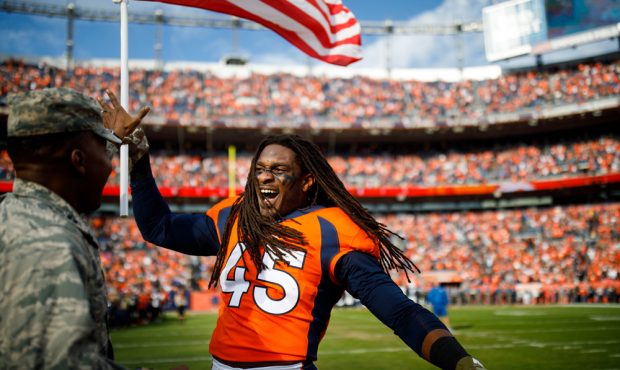 DENVER, CO - NOVEMBER 3: Linebacker Alexander Johnson #45 of the Denver Broncos hands an American F...