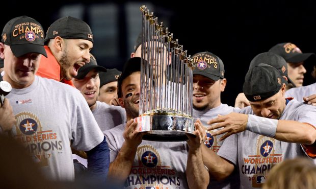 Jose Altuve #27 of the Houston Astros holds the Commissioner's Trophy after defeating the Los Angel...