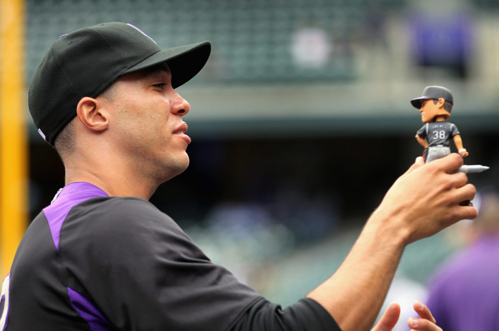 DENVER, CO - APRIL 17:  Pitcher Ubaldo Jimenez #38 of the Colorado Rockies signs his bobble head fo...