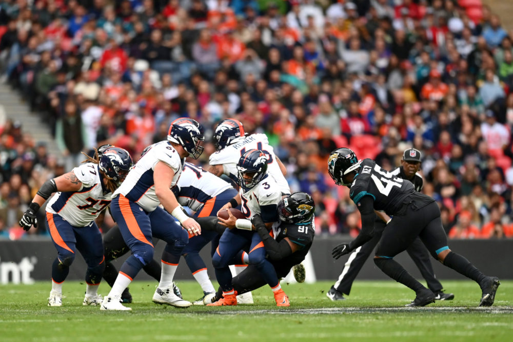 LONDON, ENGLAND - OCTOBER 30: Russell Wilson #3 of the Denver Broncos is sacked by Dawuane Smoot #9...